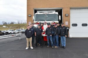 Members of the Chartiers Township Volunteer Fire Department posed around one member dressed as Santa Claus in front of a fire truck.