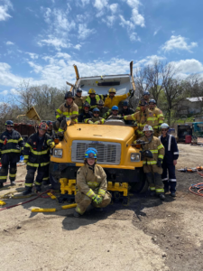 Firefighters from Chartiers Township Volunteer Fire Department pose around a school bus that has been taken apart for a demonstration.